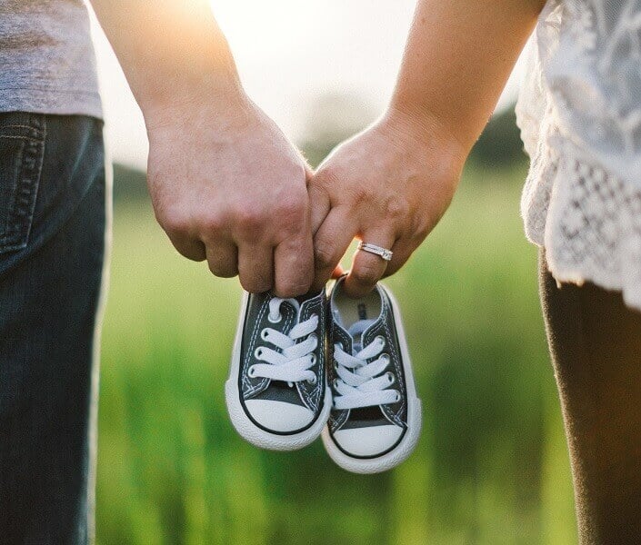 Couple holding a pair of baby shoes
