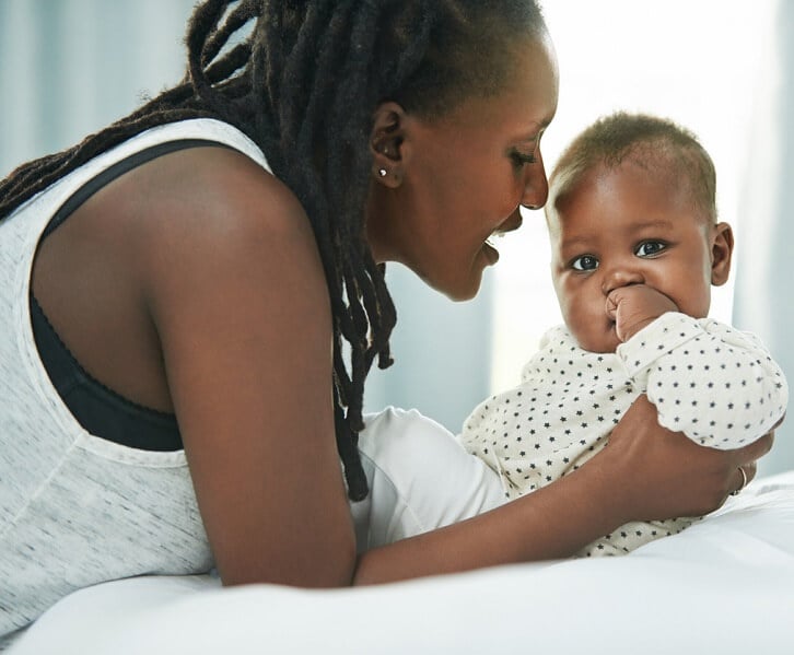 Woman on a bed with a baby