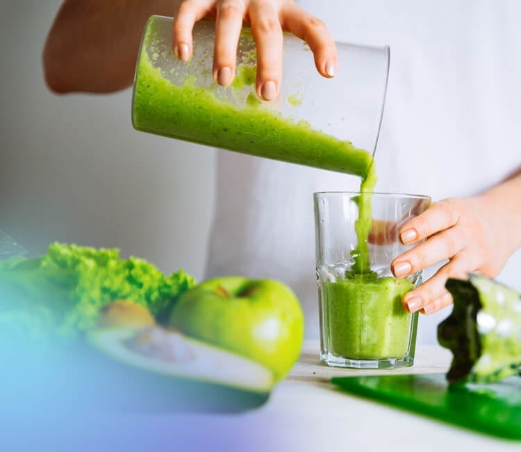 Green smoothie being poured into a glass