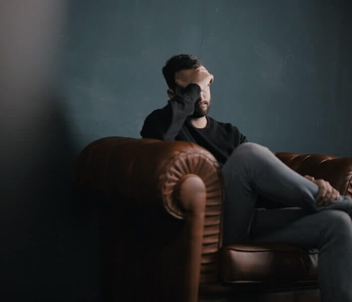 Man sat in a chair looking stressed