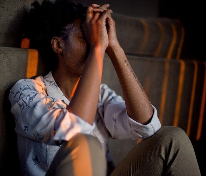 Woman sitting on some stairs looking stressed