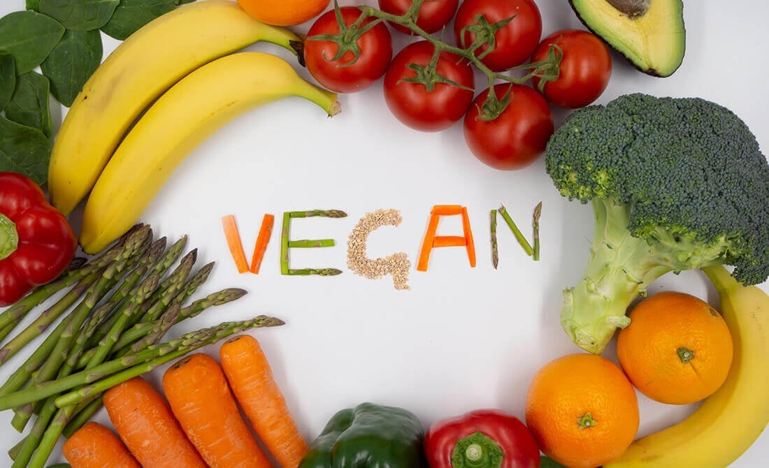 Fruit and vegetables surrounding the word vegan
