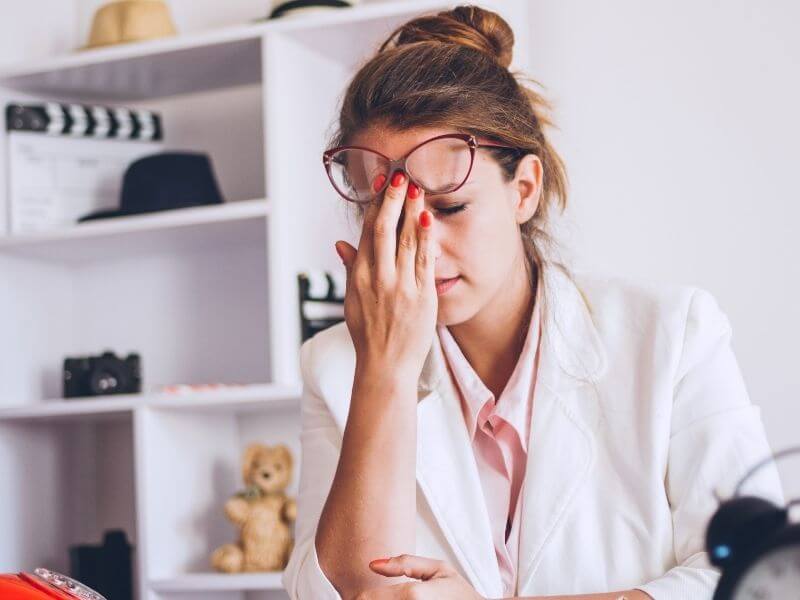 Woman sat at a desk looking tired