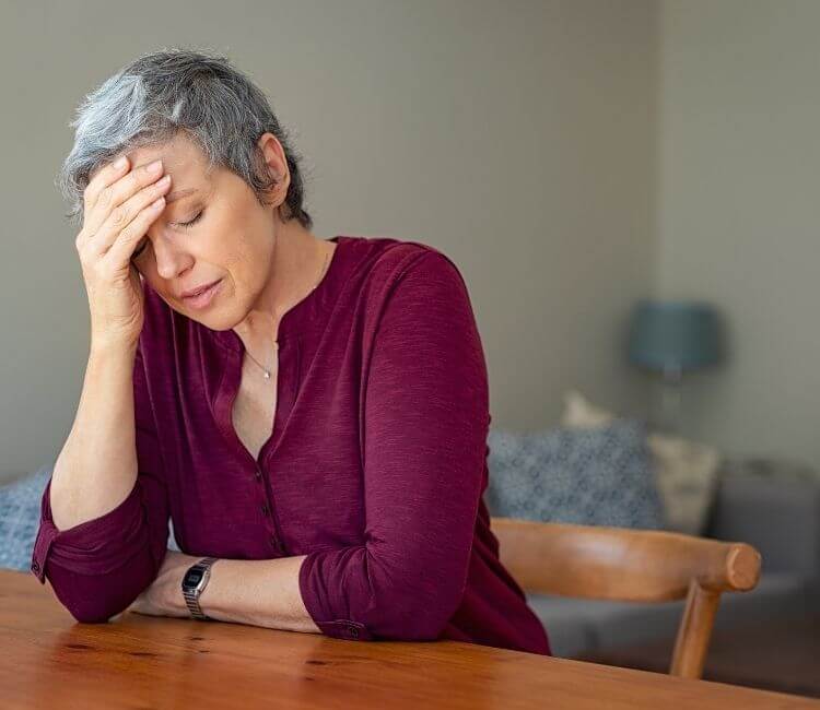 Older-woman-with-head-in-her-hands-750x650