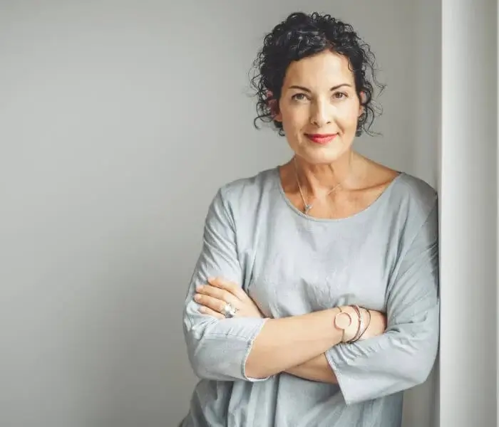 Woman with dark curly short hair in her 40s