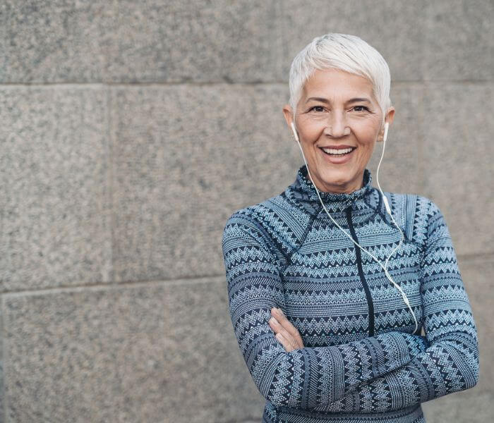 Grey haired woman wearing to head phones