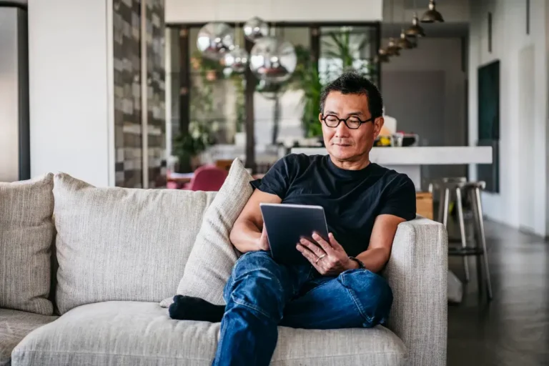 Middle aged man on sofa using tablet