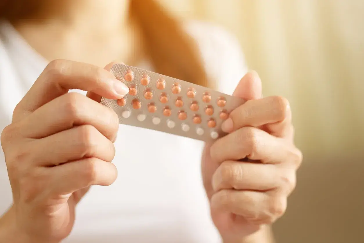 A woman holding her contraceptive pills