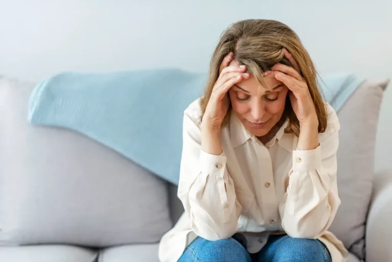 Menopausal woman holding head in hands