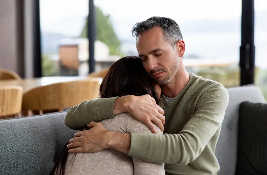 A husband comforting his wife who is suffering from perimenopause symptoms